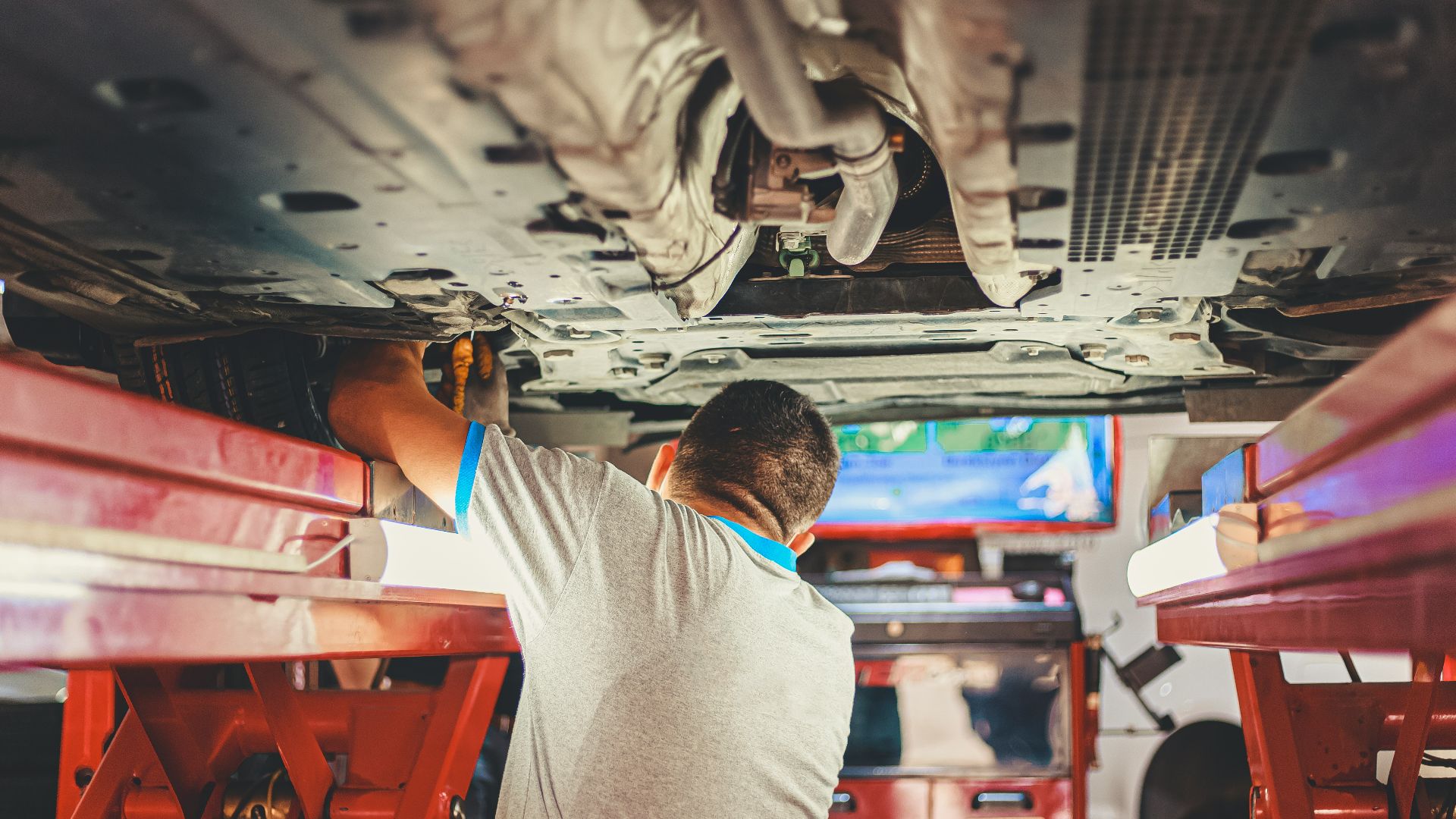 man in gray shirt sitting on red plastic chair