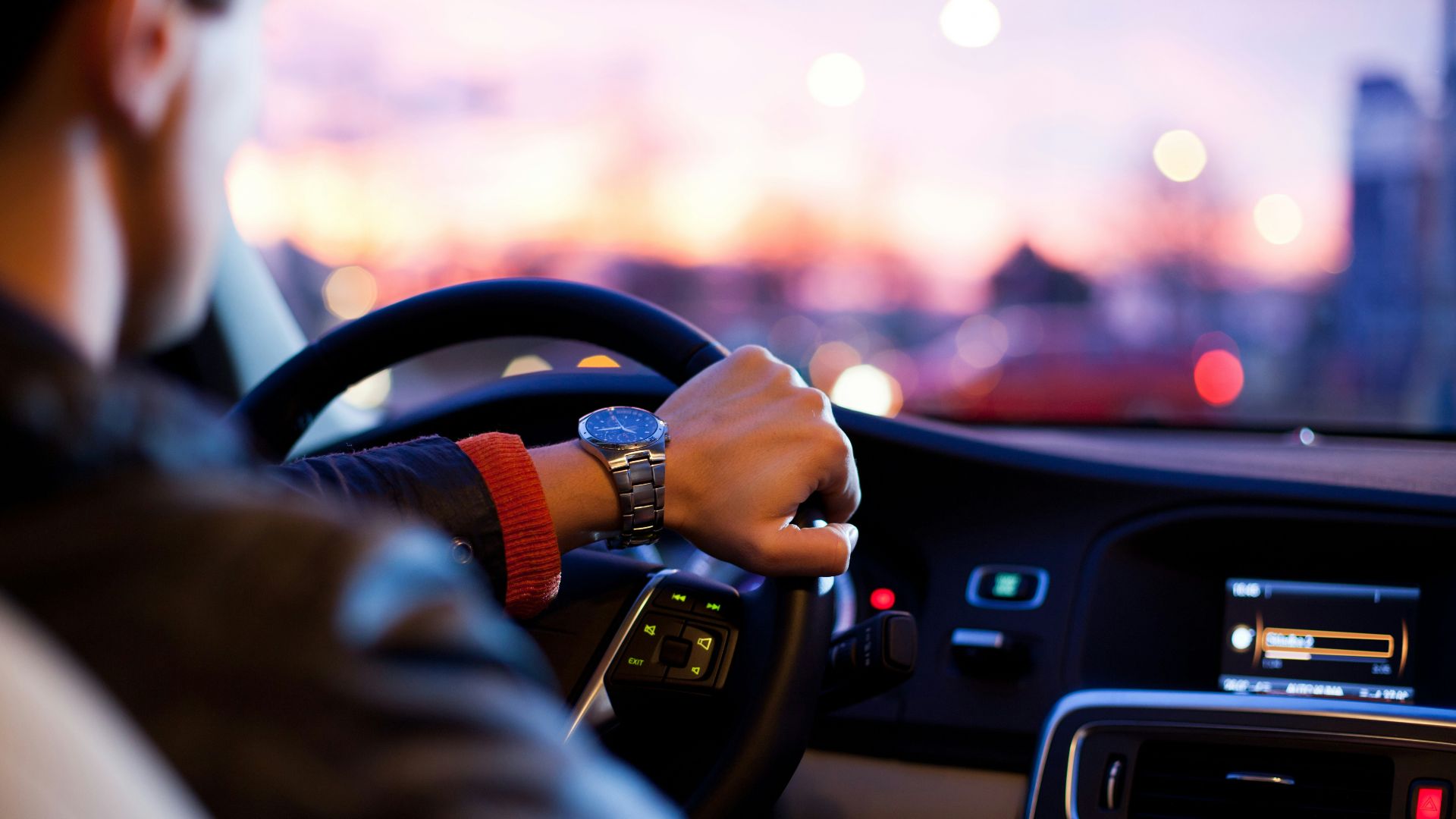 man driving a car wearing wrist watch