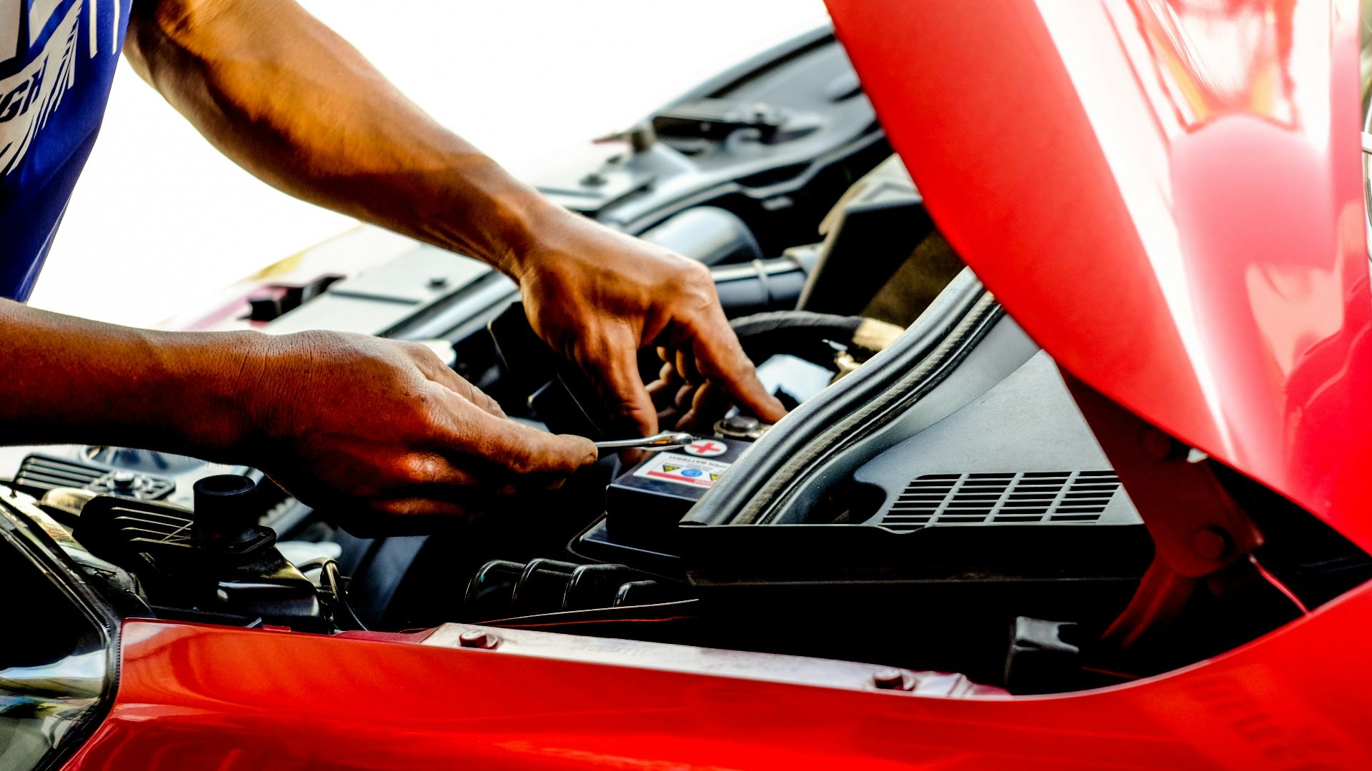 person fixing car during daytime