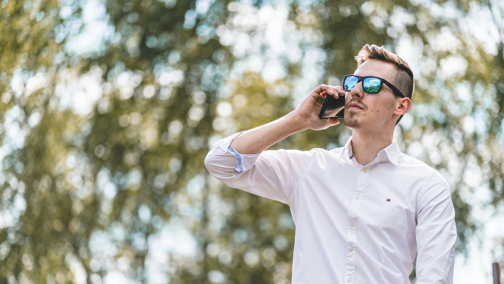 man in white polo shirt wearing blue sunglasses