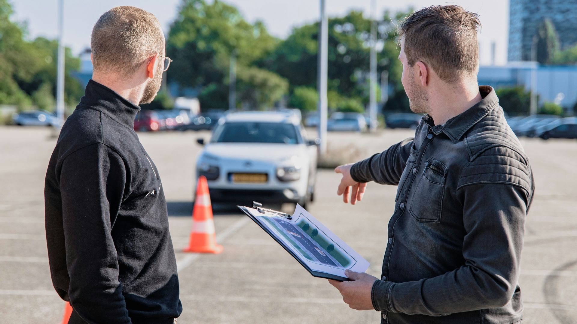 man in black jacket holding blue tablet computer