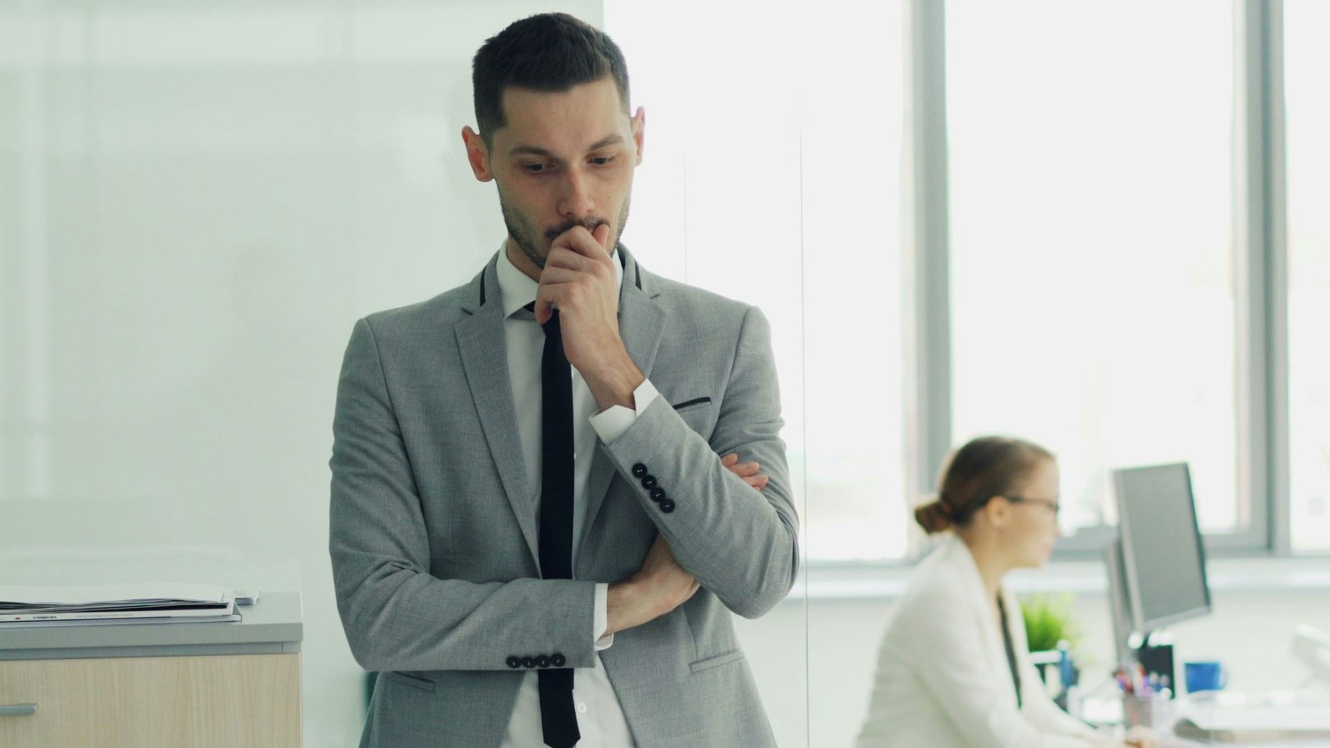 Man in suit thinking in modern office environment