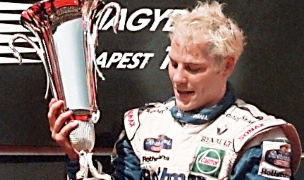 Gettyimages - 2068296652, F1-VILLENEUVE Canadian Williams-Renault driver Jacques Villeneuve looks at his trophy on the podium after winning the Hungarian Formula One Grand Prix 10 August. British Damon Hill came in second and Johnny Herbert third.