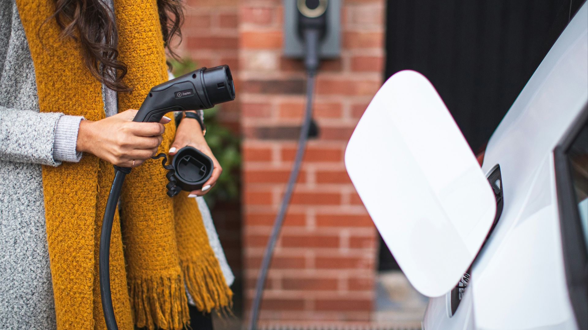 a woman is pumping gas into her car