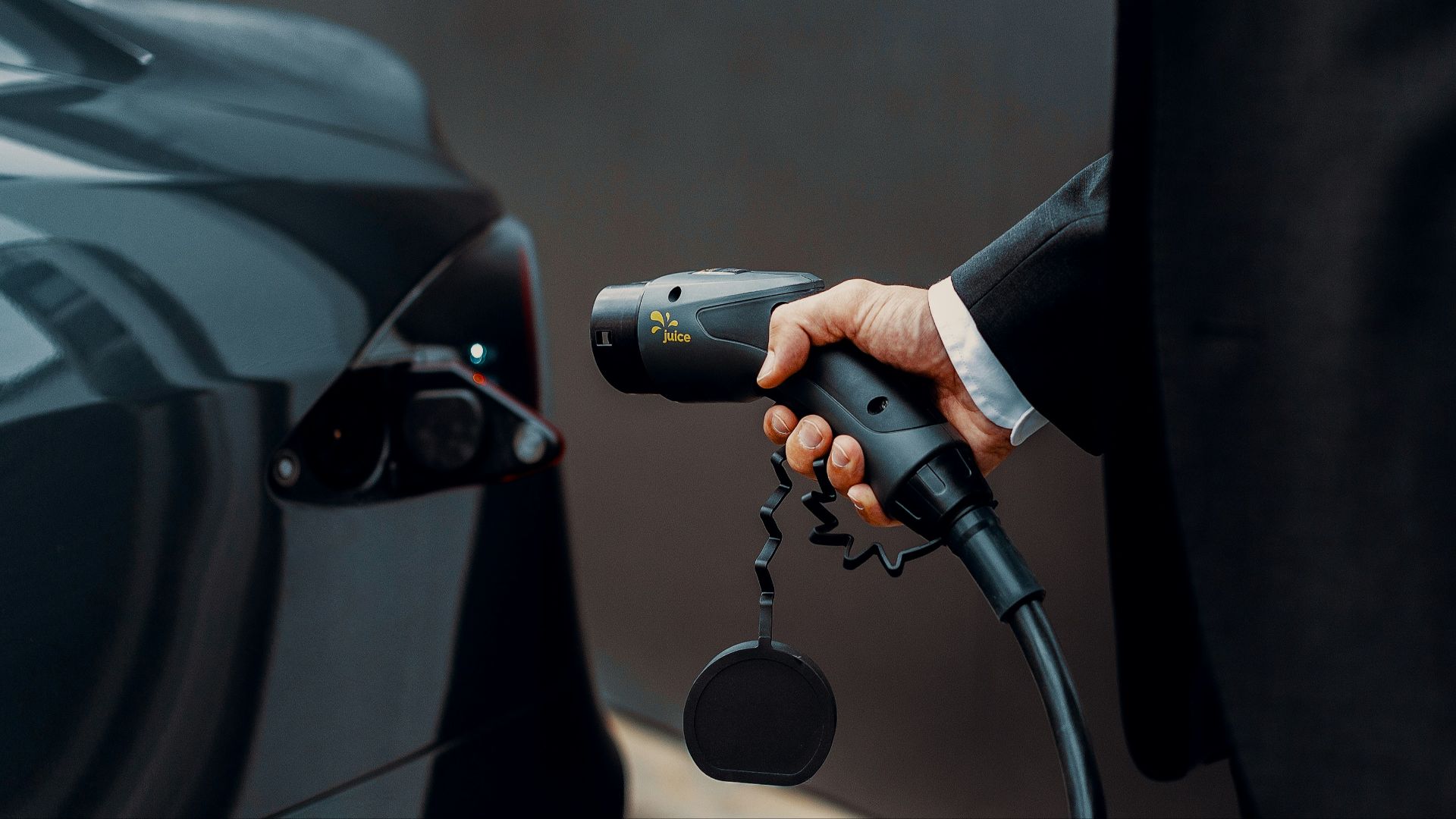a man in a suit is pumping gas into a car