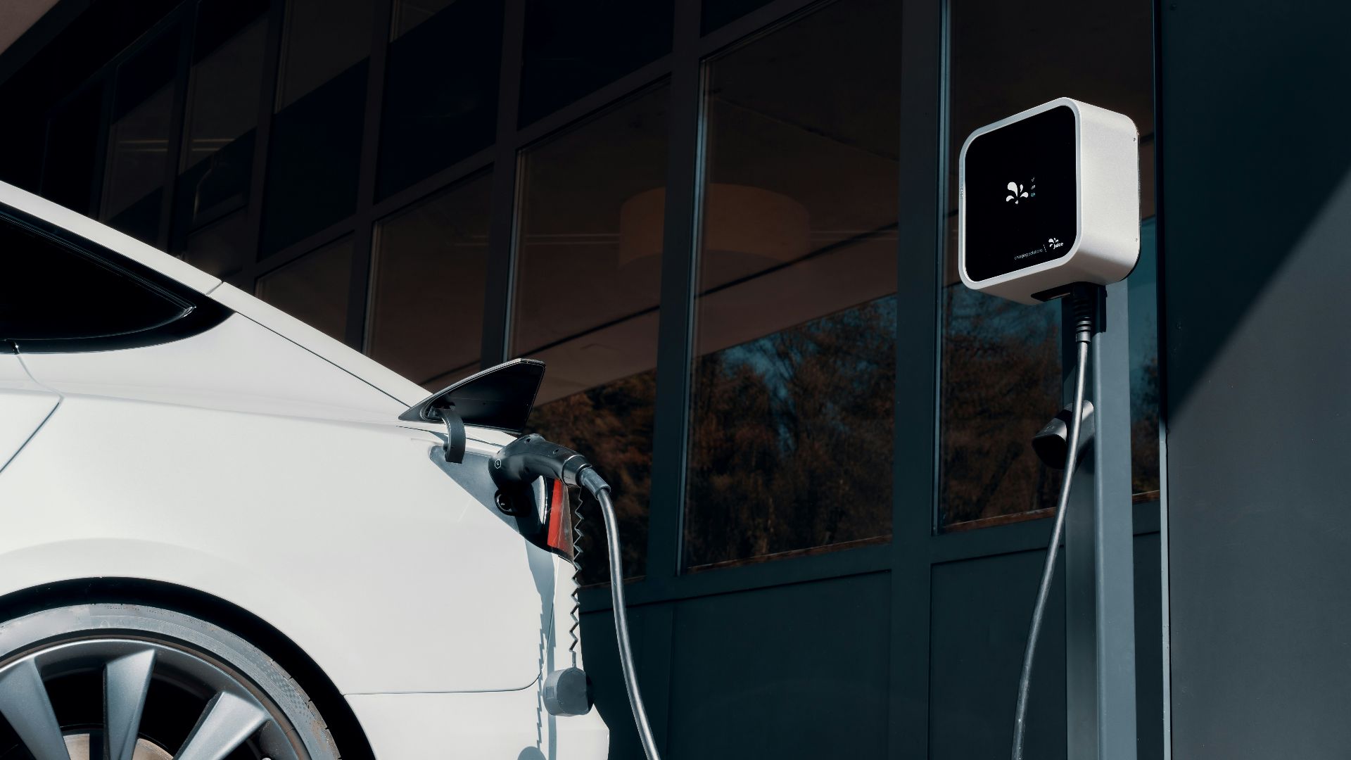 a white car plugged in to a charging station