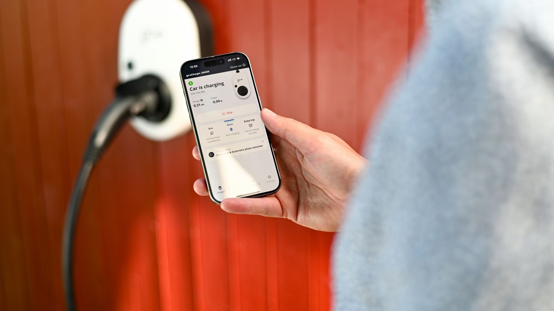 Person uses phone to control electric vehicle charger.