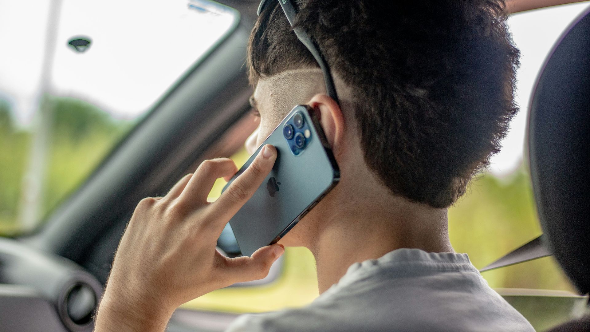man in white crew neck shirt wearing black framed eyeglasses holding silver iphone 6
