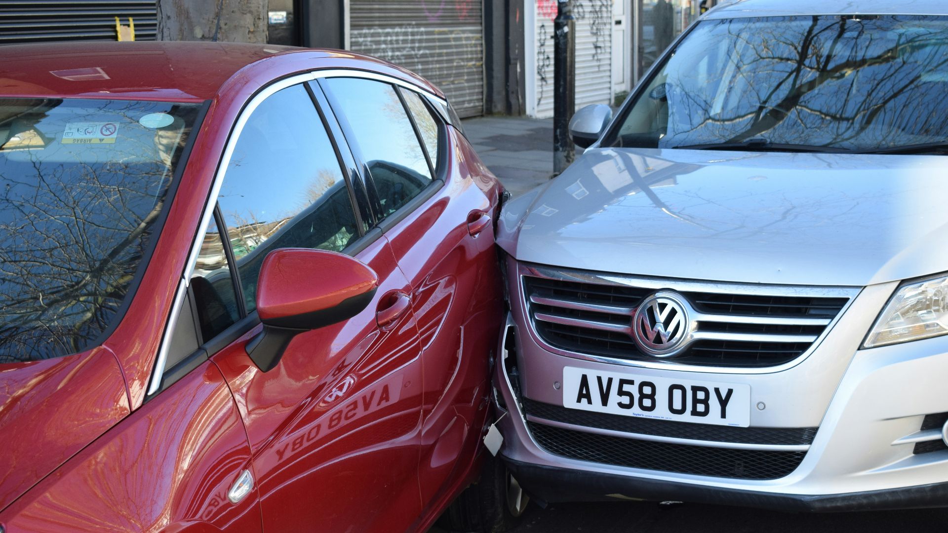 two cars parked next to each other in a parking lot