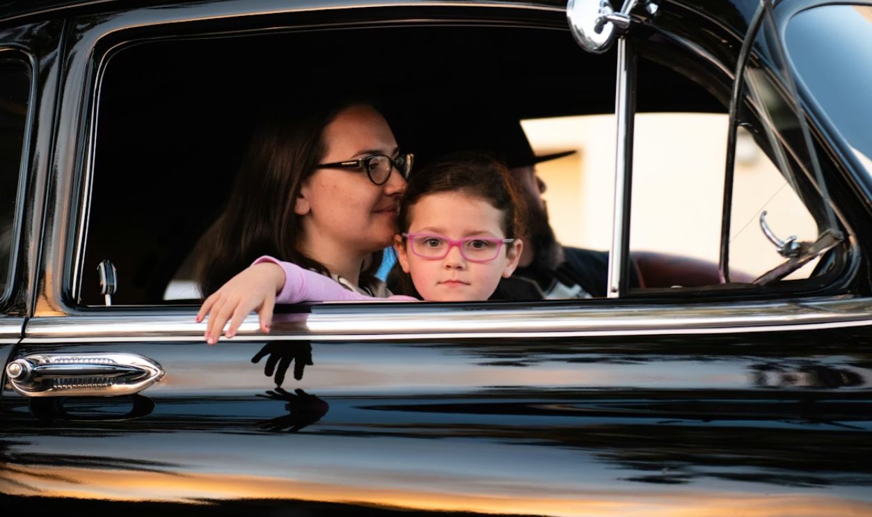 child seated on a driver's lap