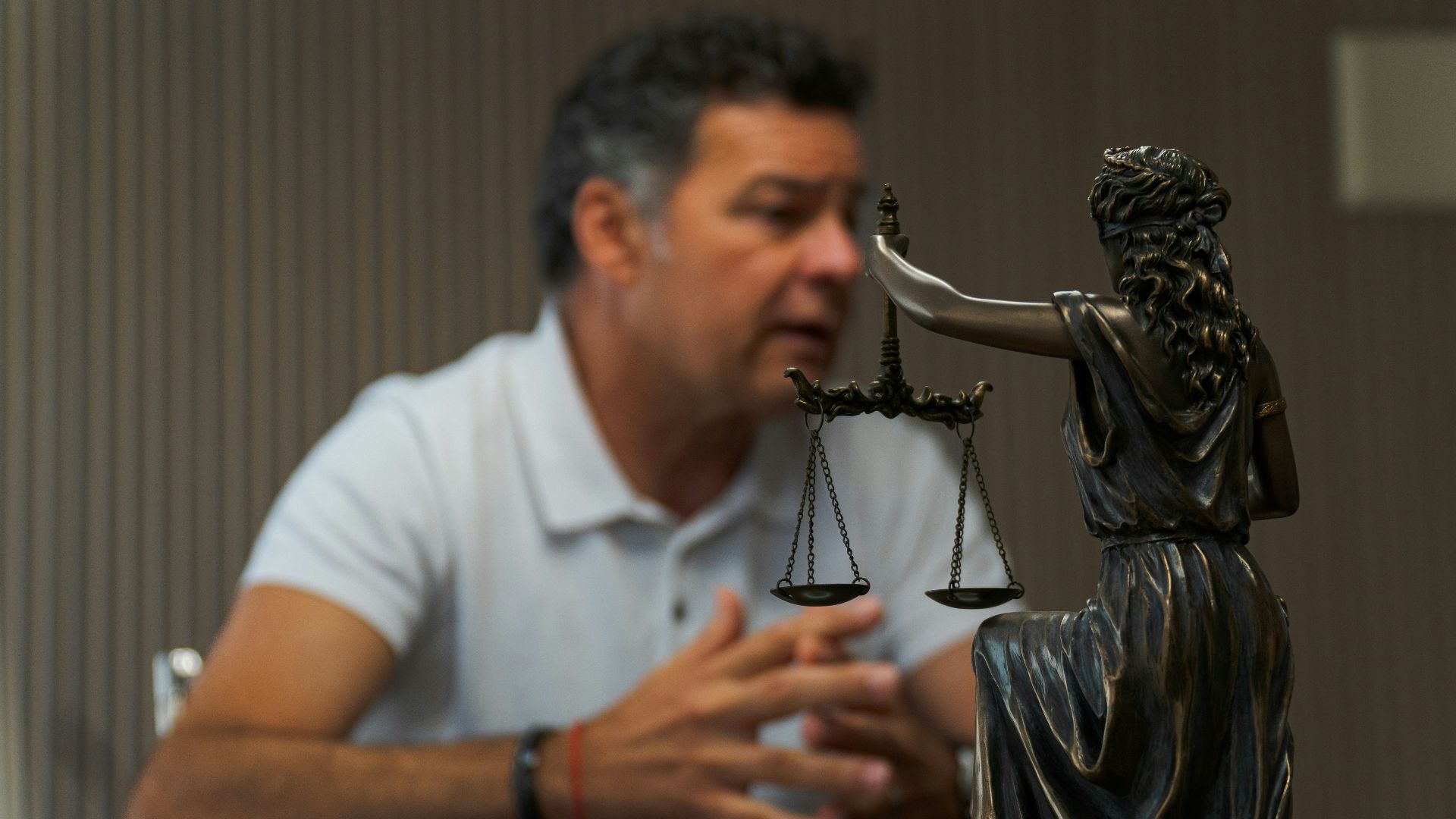 A man sitting at a table in front of a statue