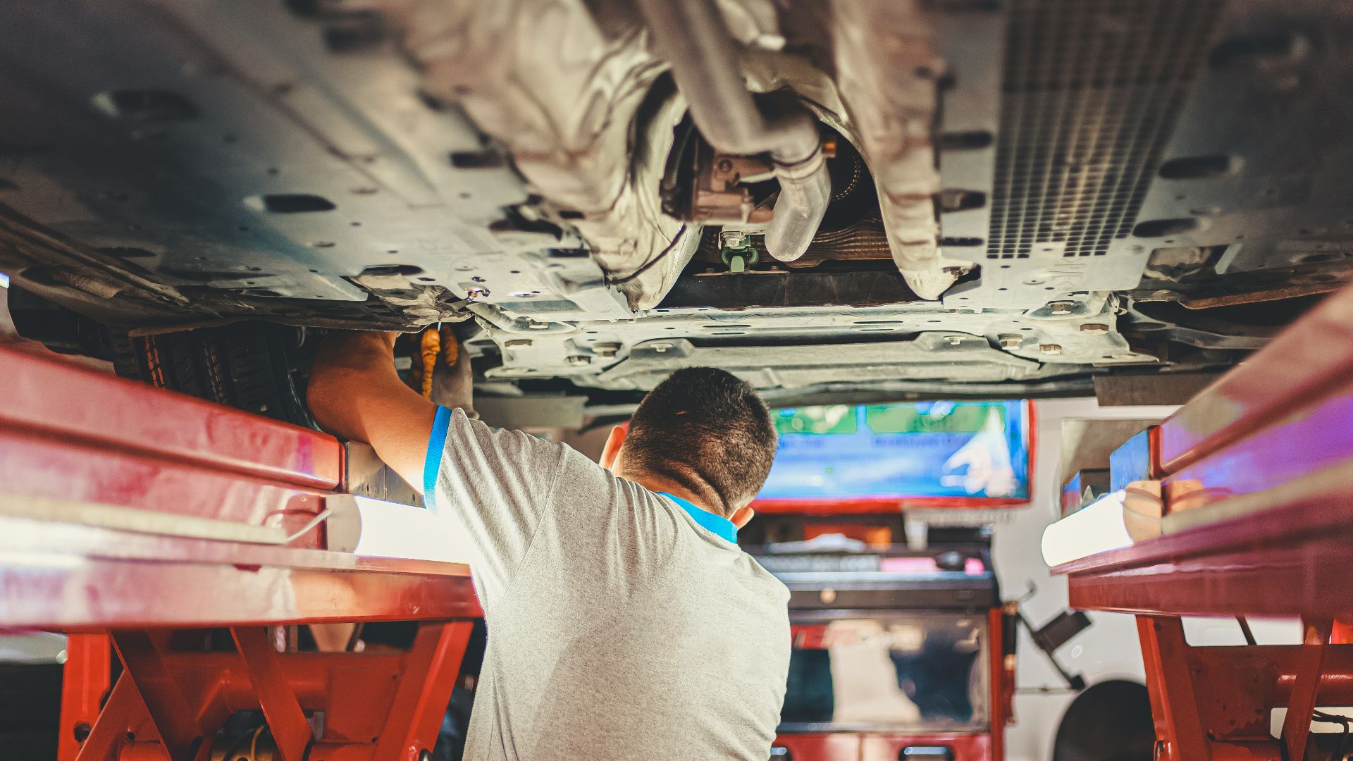 man in gray shirt sitting on red plastic chair