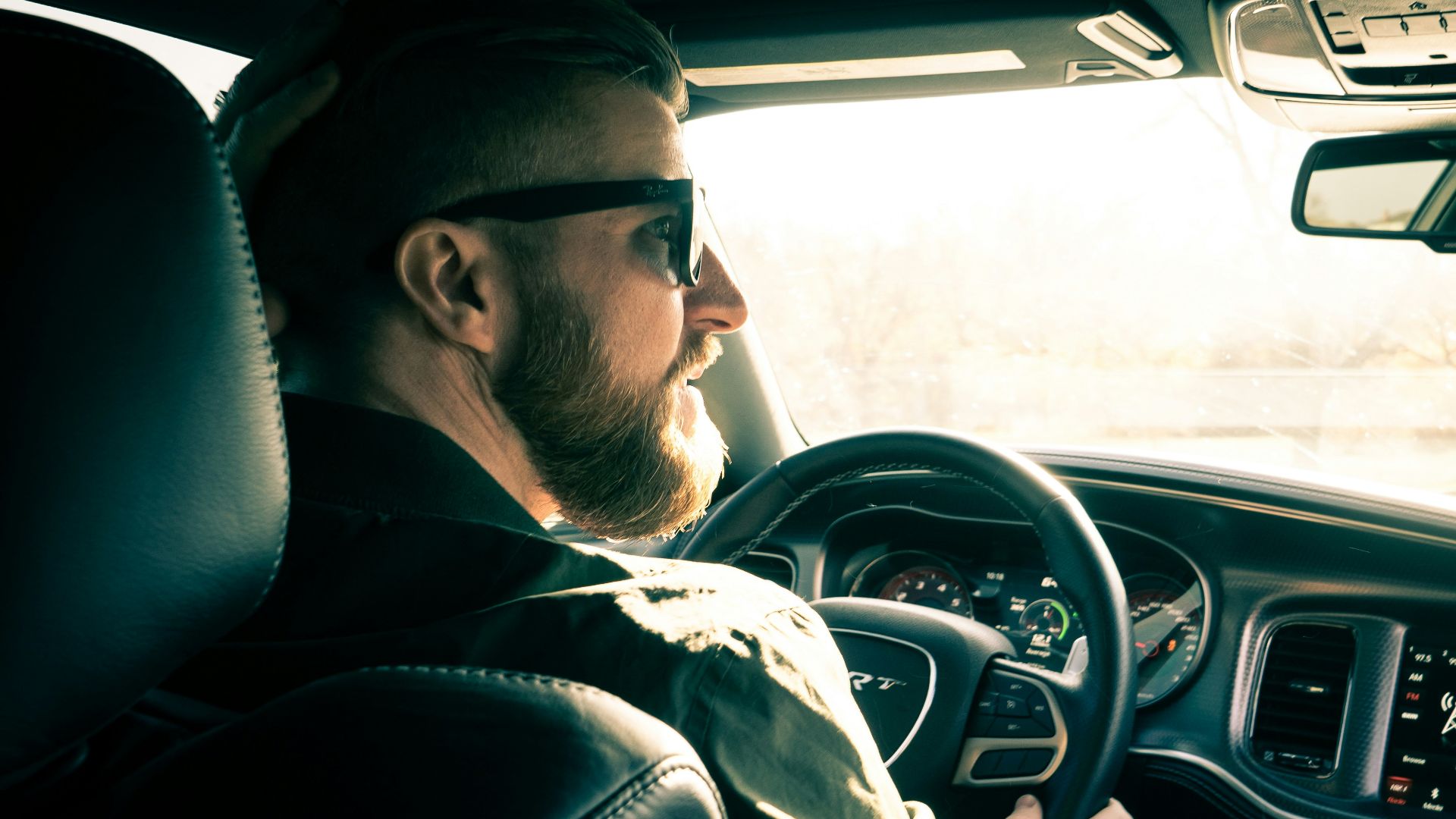 man in black jacket driving car