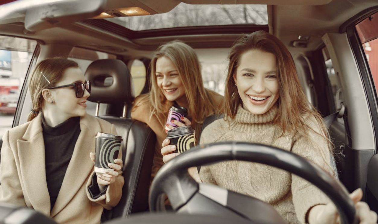 Friends driving around city with coffee