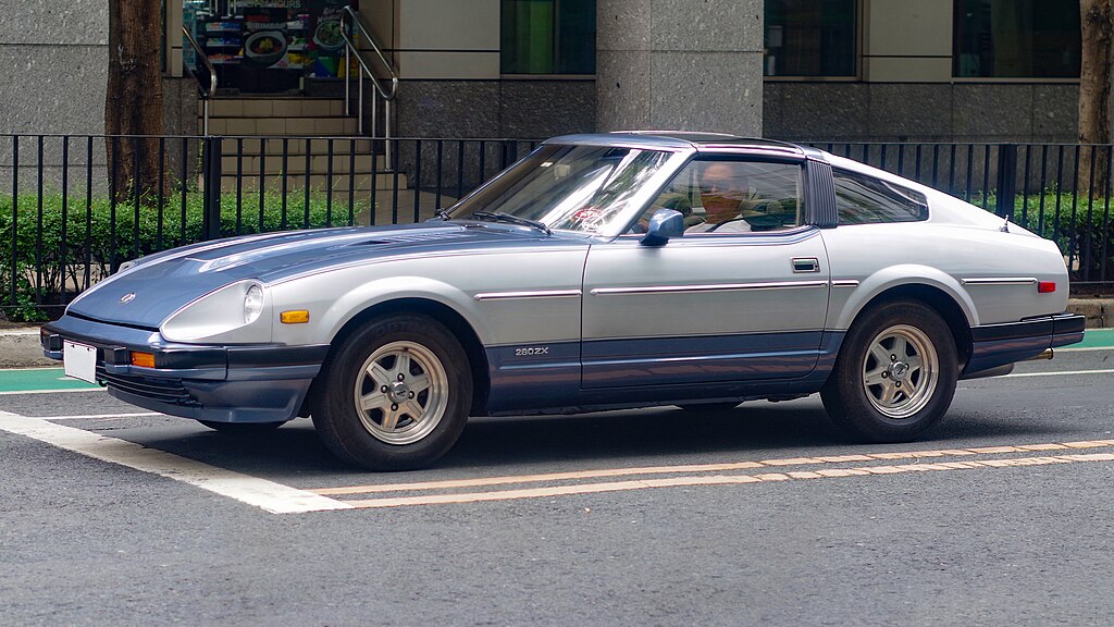 A close-up photo of a 1983 Datsun 280ZX car parked in a parking lot