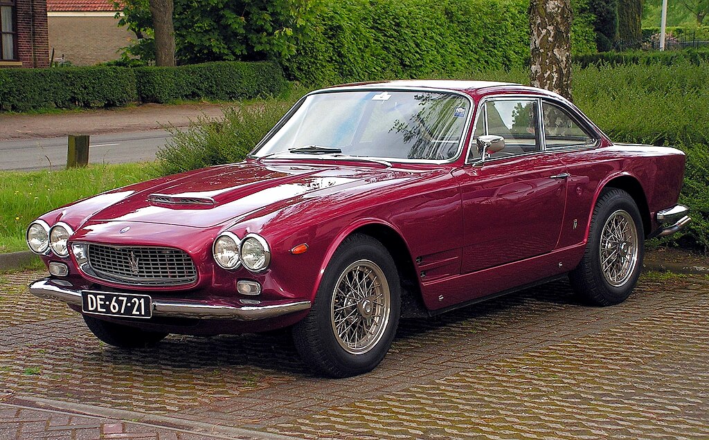 A close-up photo of a 1963 Maserati Sebring car parked in a parking lot