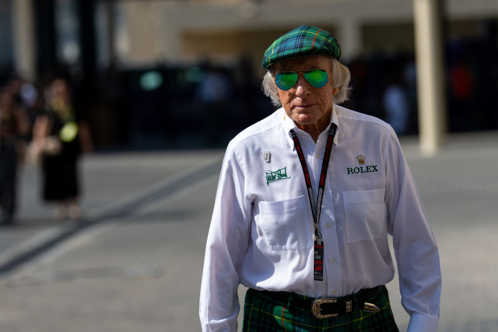 Sir Jackie Stewart walks through the paddock during practice