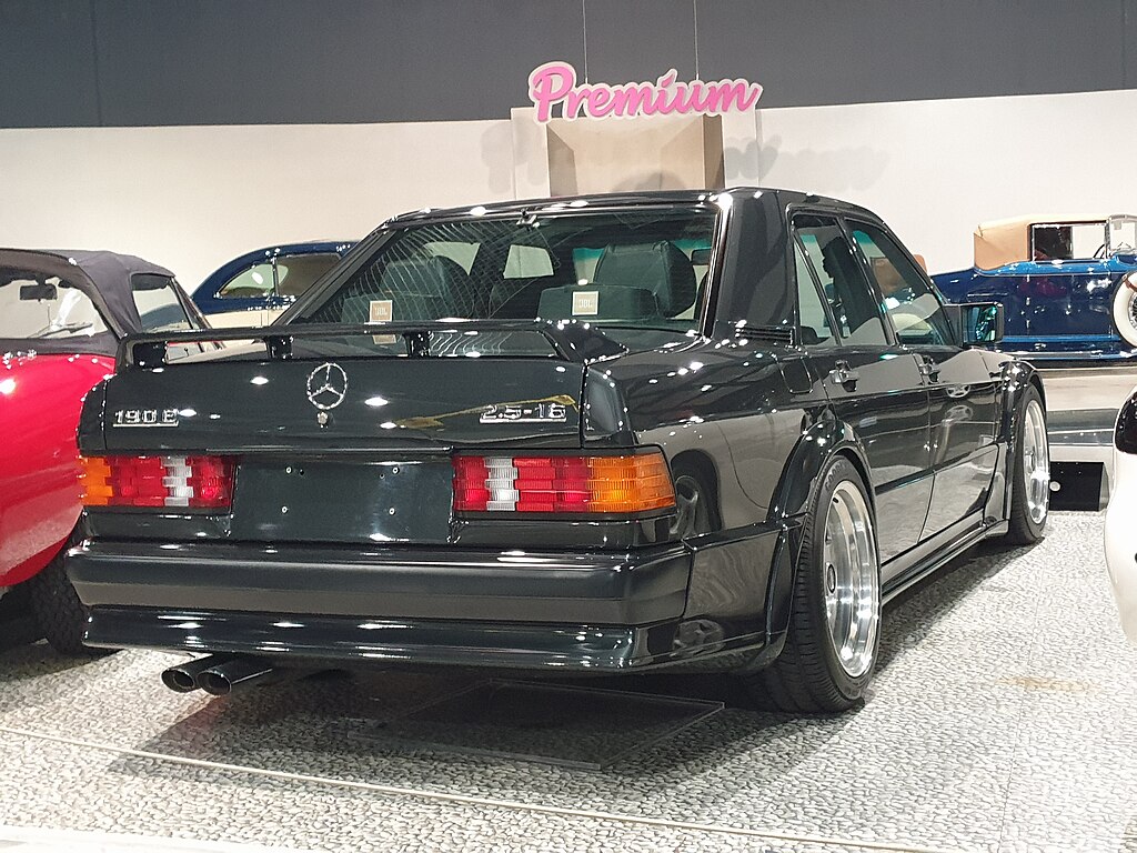 A close-up photo of a 1989 Mercedes-Benz 190E car on display at an exhibition