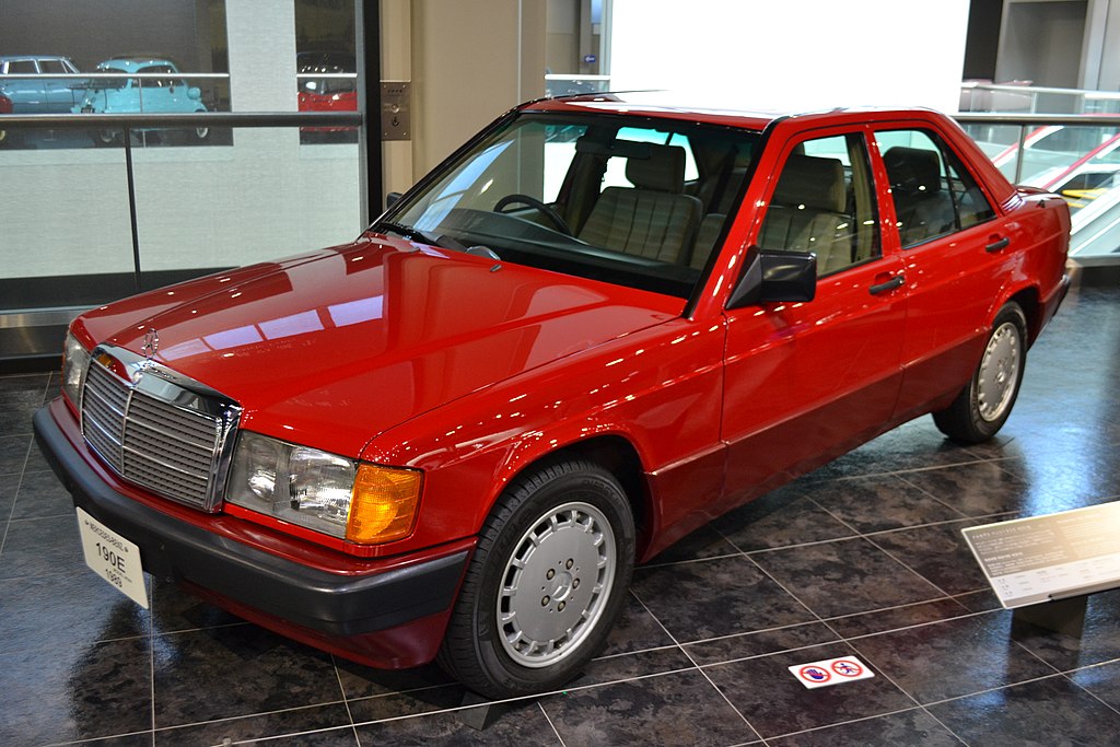 A close-up photo of a 1989 Mercedes-Benz 190E car on display at an exhibition