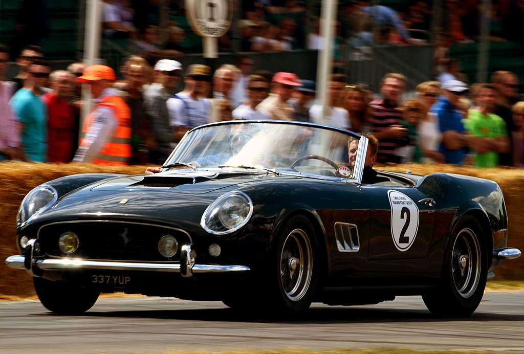 A close-up photo of a Ferrari 250 GT SWB California Spyder car in motion