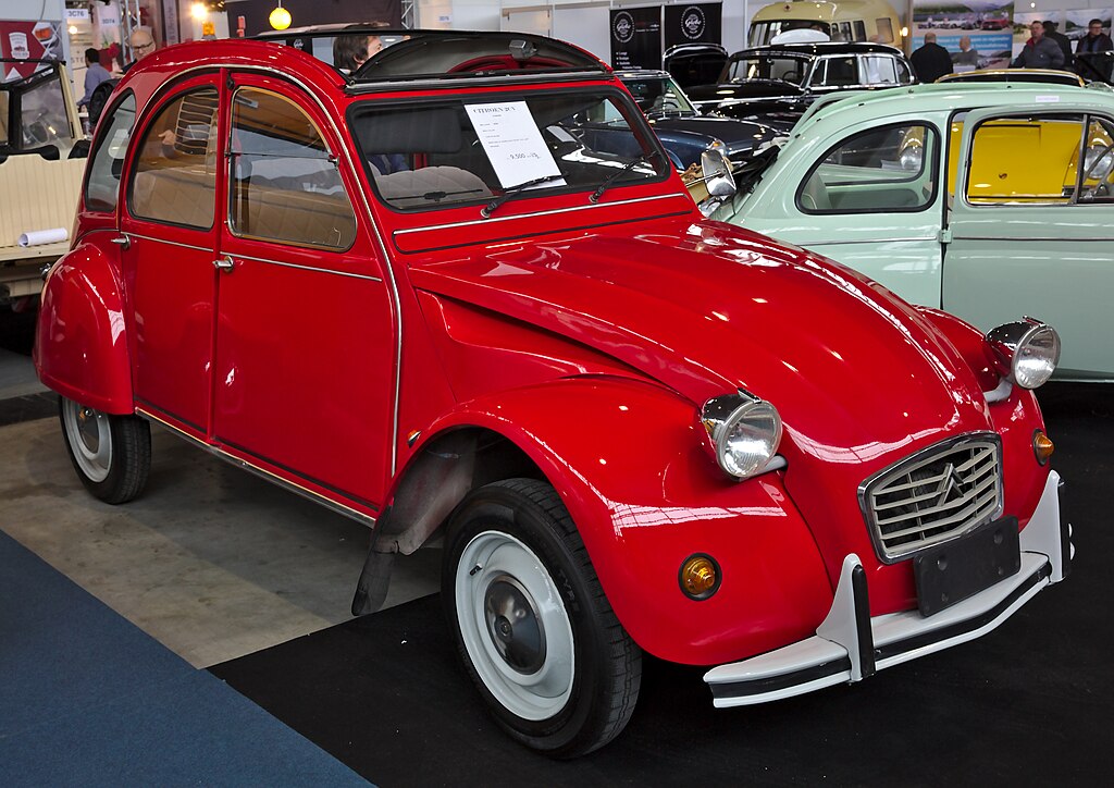 A close-up photo of a Citroën 2CV car on display at an exhibition