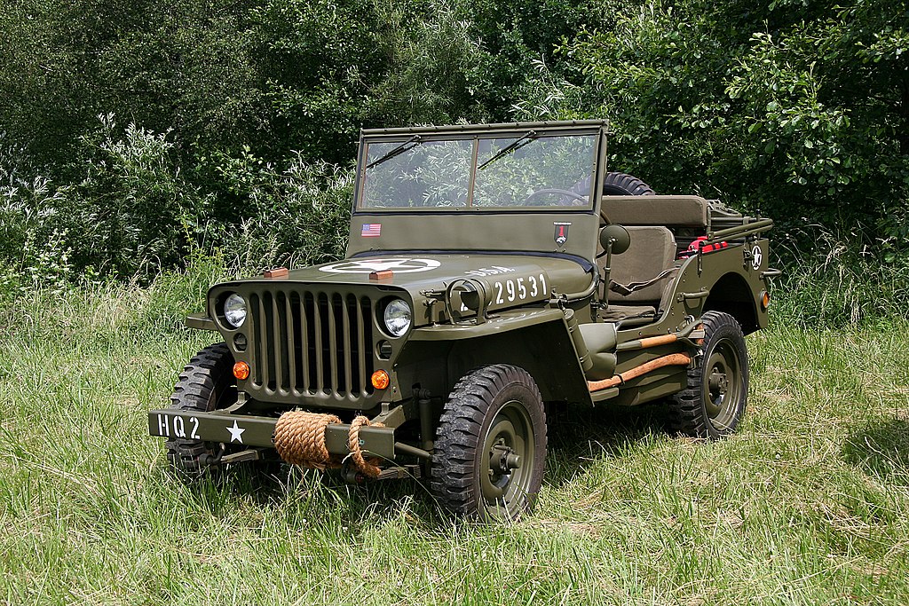A close-up photo of a Willys Jeep car parked in a naturel environment
