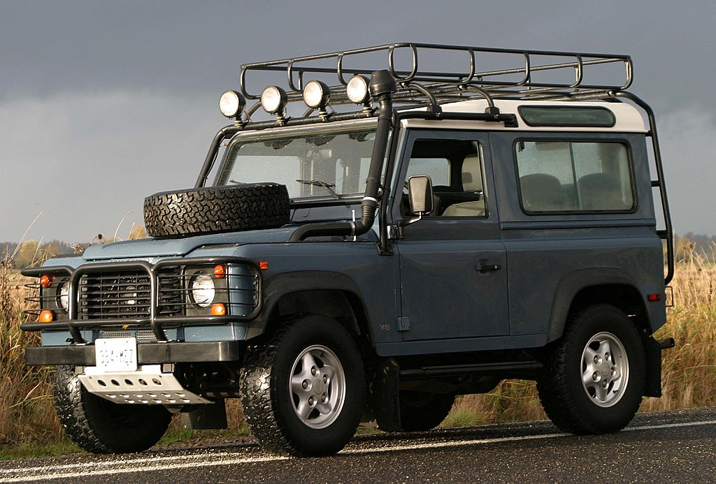 A close-up photo of a Land Rover Defender car parked in an open road