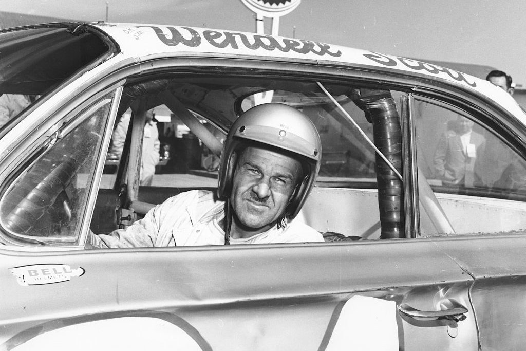 Wendell Scott poses for a portrait in his car as he became the first African-American driver to win in the NASCAR Cup division