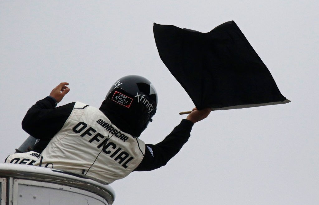 The Xfinity official waves the black flag to a competitor