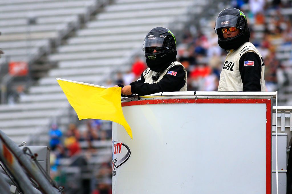 The NASCAR Officials display the yellow caution flag