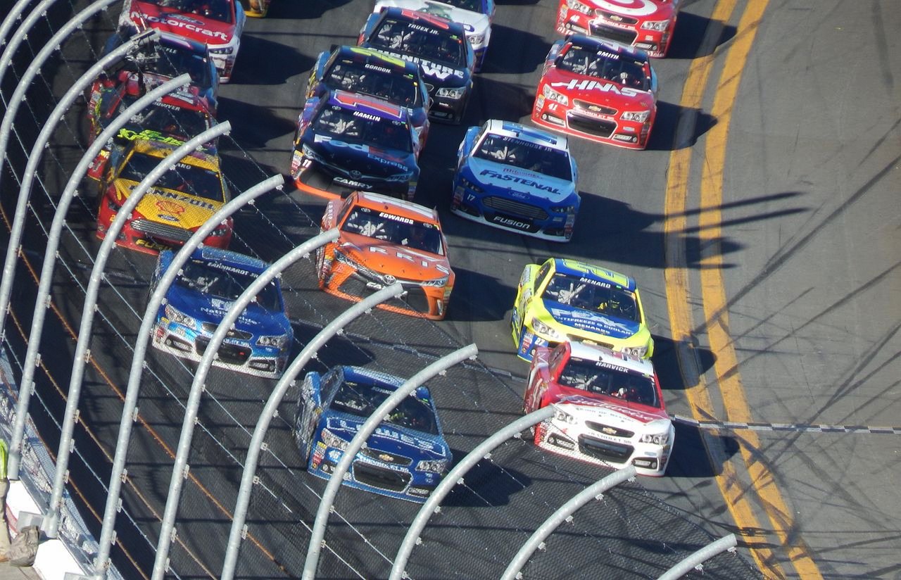 The field racing three-wide multiple rows back at Daytona International Speedway.