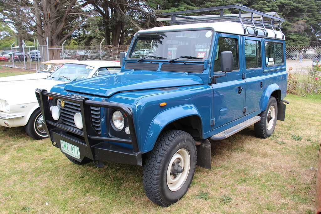 A close-up photo of a Land Rover Defender car parked in a parking lot
