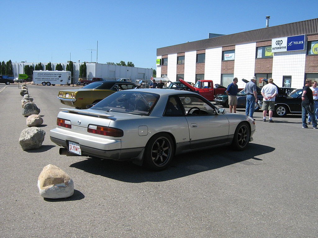 A close-up photo of a Nissan Silvia S13 car on display at an exhibition