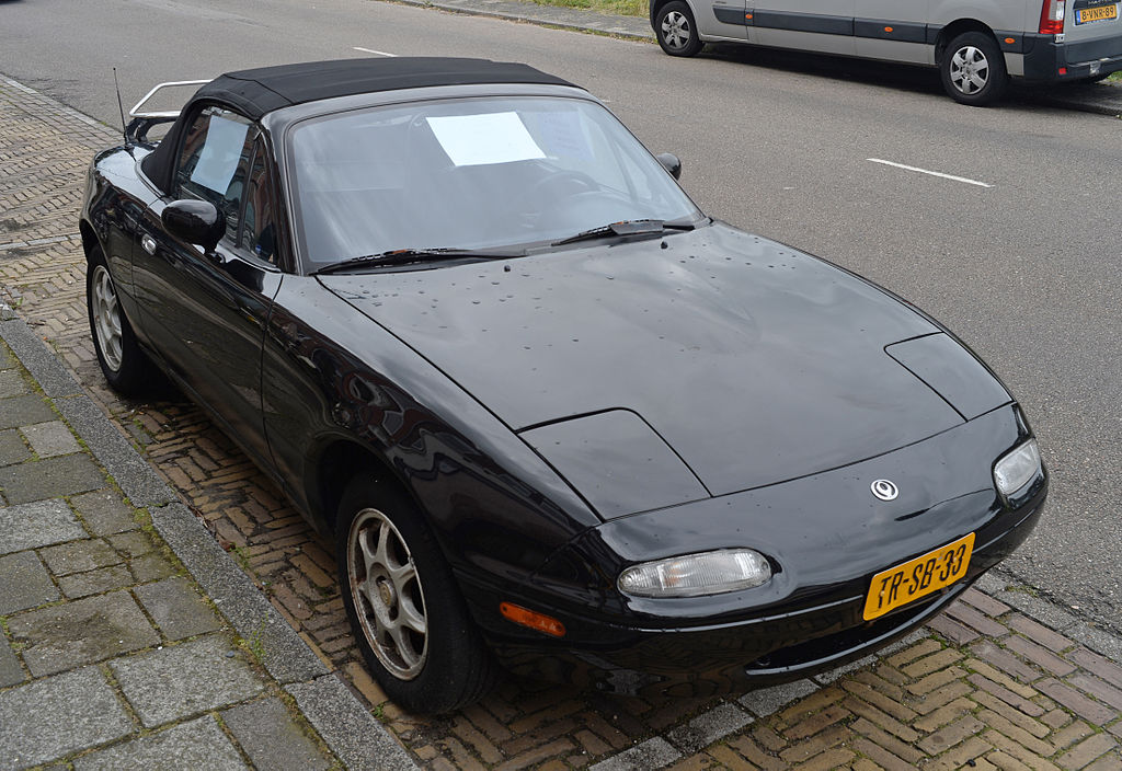 A close-up photo of a Mazda Miata car parked in a parking lot