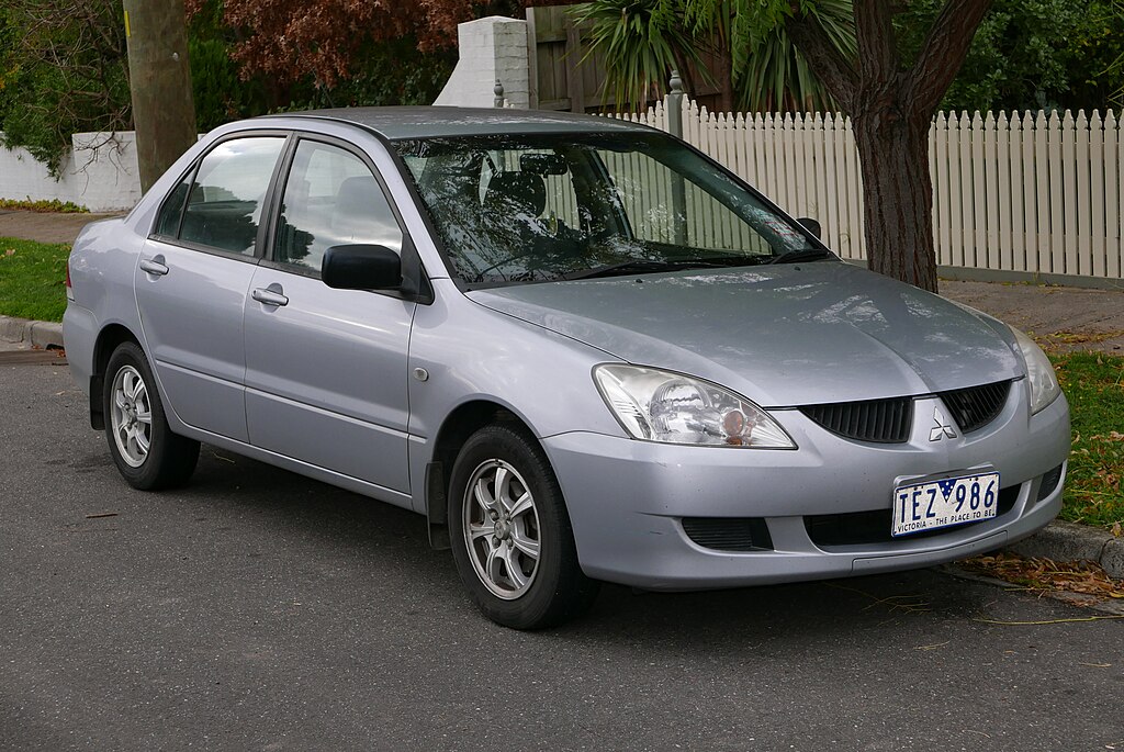 A close-up photo of a Mitsubishi Lancer car parked in a parking lot