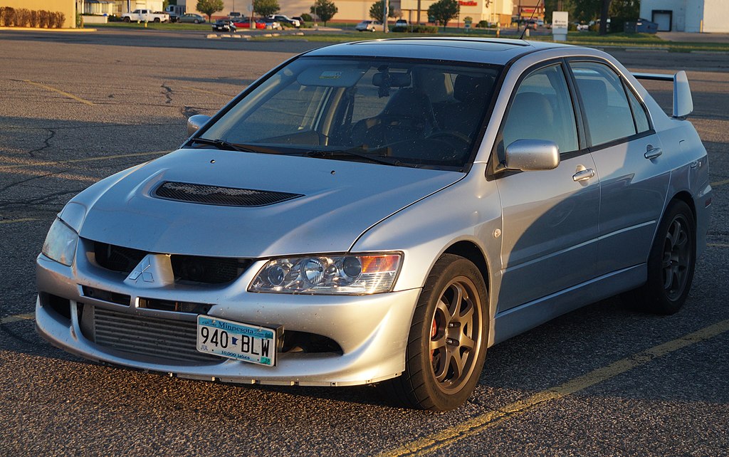A close-up photo of a Mitsubishi Lancer car parked in a parking lot