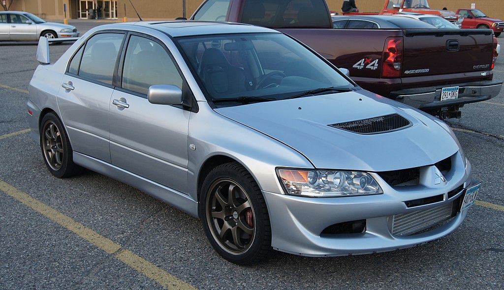 A close-up photo of a Mitsubishi Lancer car parked in a parking lot