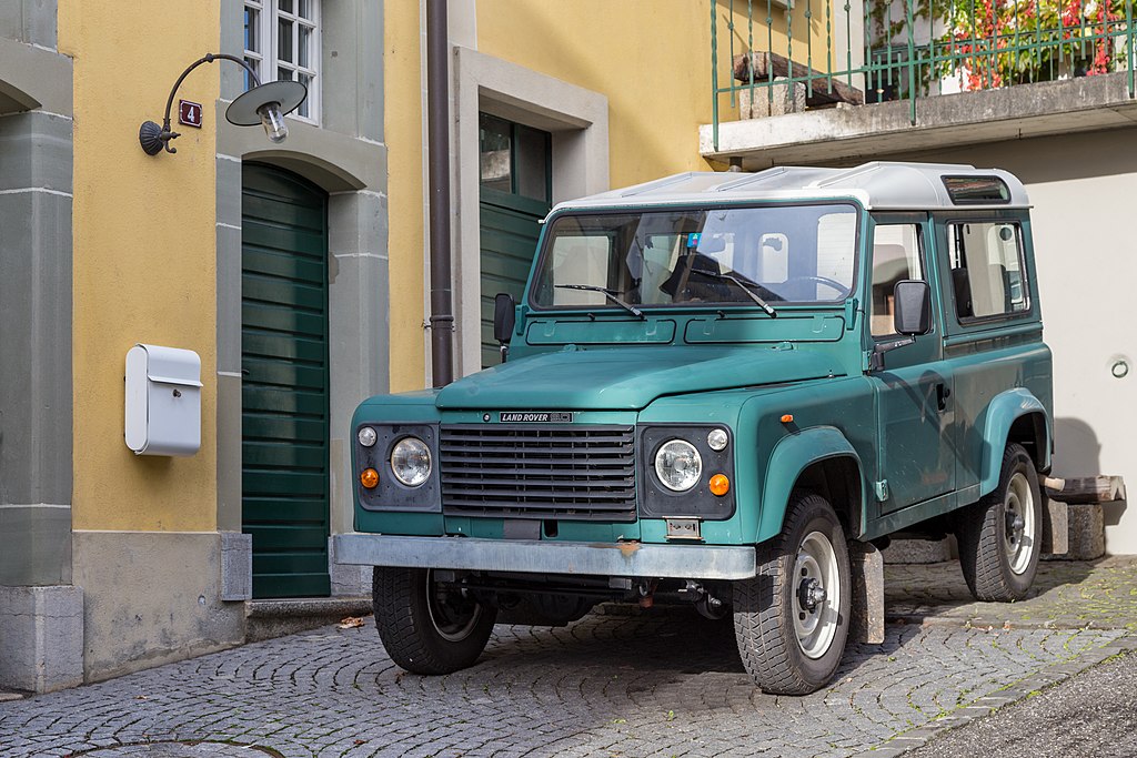 A close-up photo of a Land Rover Defender car parked in a parking lot