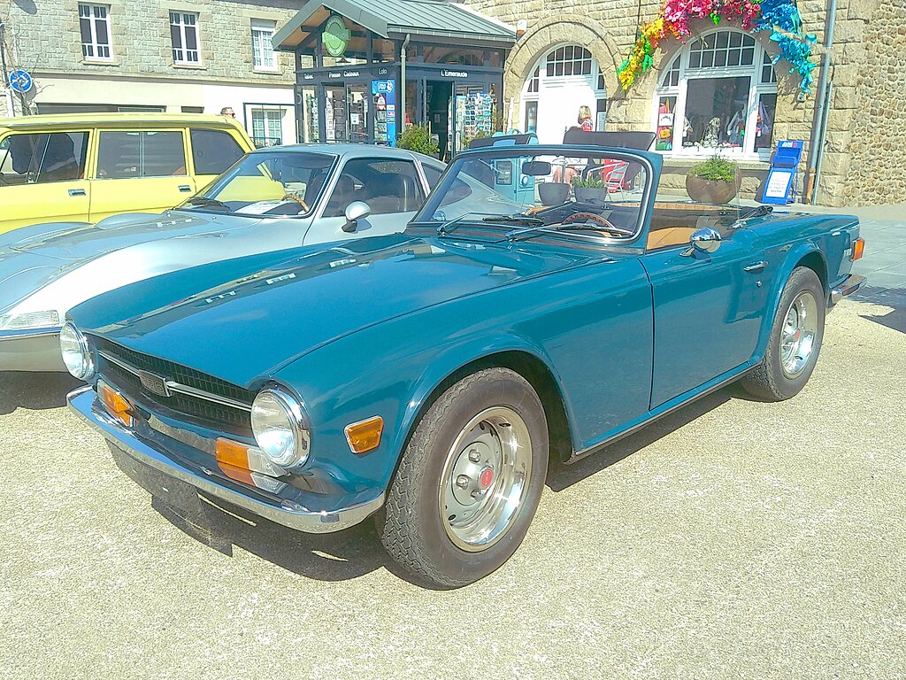 A close-up photo of a Triumph TR6 car parked in a parking lot