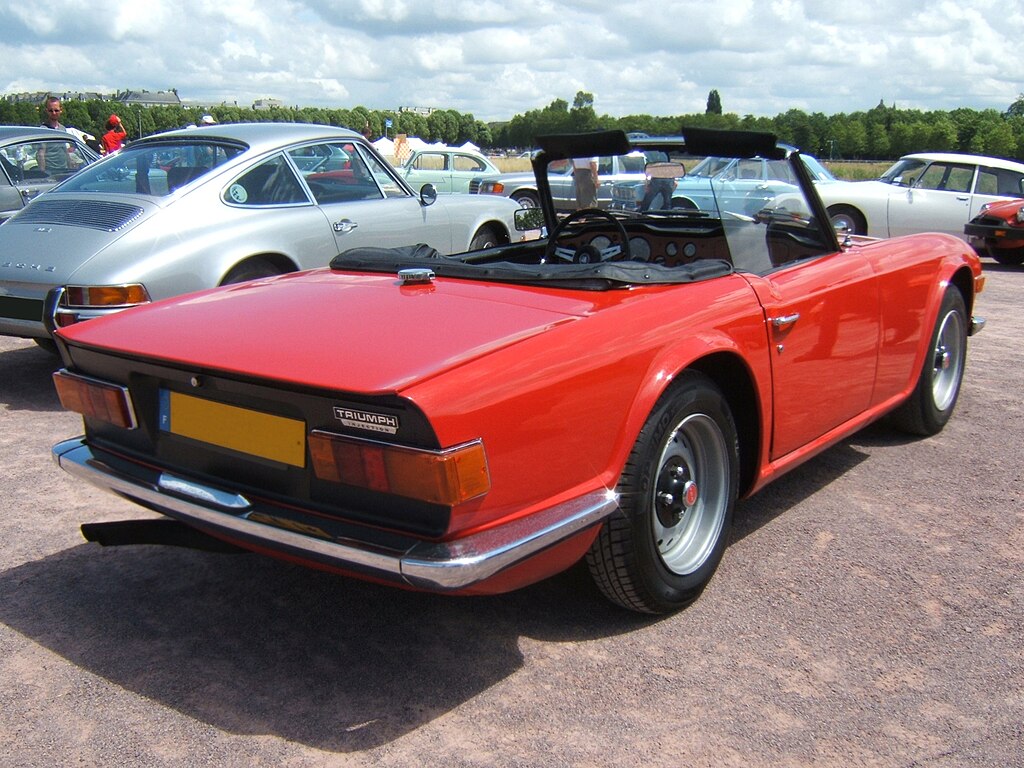A close-up photo of a Triumph TR6 car parked in a parking lot