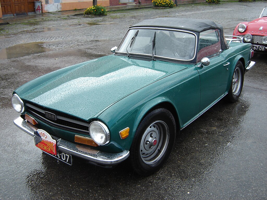 A close-up photo of a Triumph TR6 car parked in a parking lot