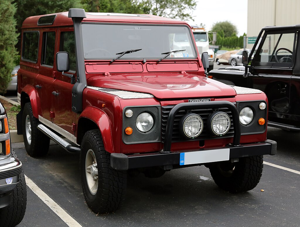 A close-up photo of a Land Rover Defender car parked in a parking lot