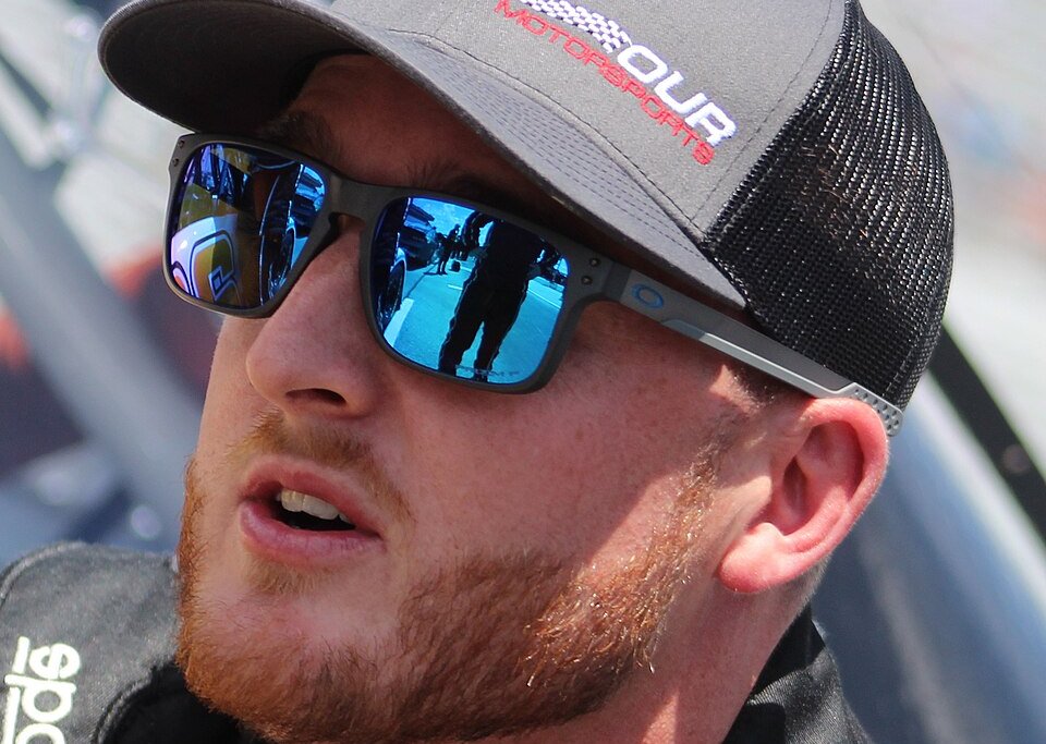Ty Dillon wearing a pair of sunglasses and a cap