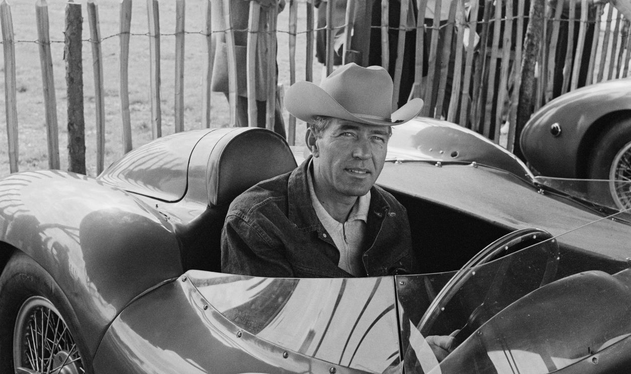 American racing driver Carroll Shelby (1923-2012) sits in an Aston Martin DBR 1/300 race car in the paddock ahead of the RAC Tourist Trophy race, Goodwood, Sussex, September 13th 1958.