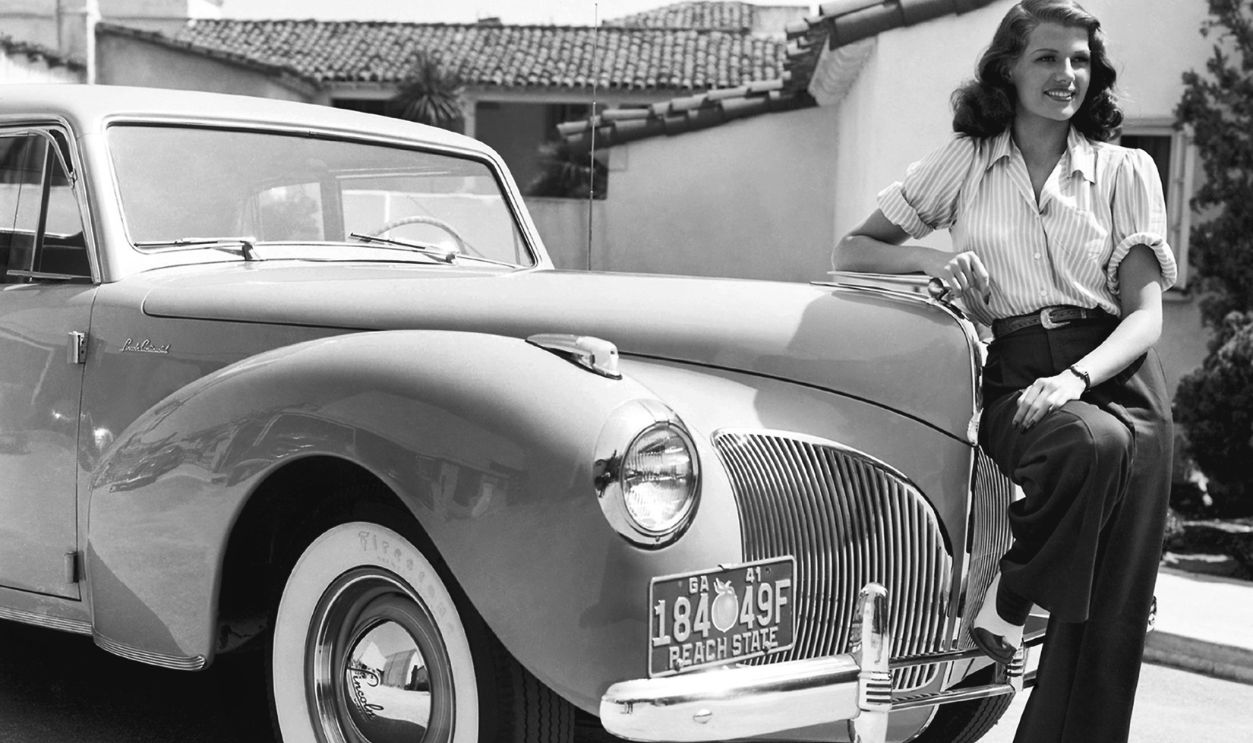 Actress Rita Hayworth poses for a publicity still next to a Georgia-registered Lincoln Continental car, 1941.