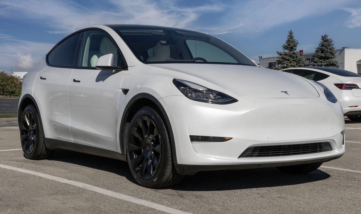 Used Tesla Model Y display at a dealership. To meet high demand, Tesla buys and sells pre-owned cars.