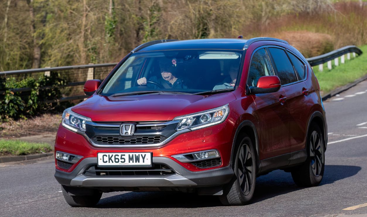 2016 red Honda CR-V diesel car driving on an English road