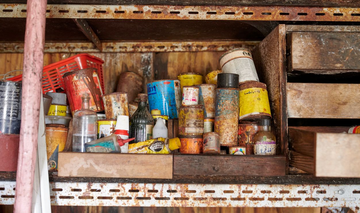 Rustic shelf with vintage tools and old rusty containers in a workshop - stock photo Rustic shelf in a workshop containing old tools, rusty containers, and weathered materials, showcasing a nostalgic and practical ambiance with aged industrial elements.