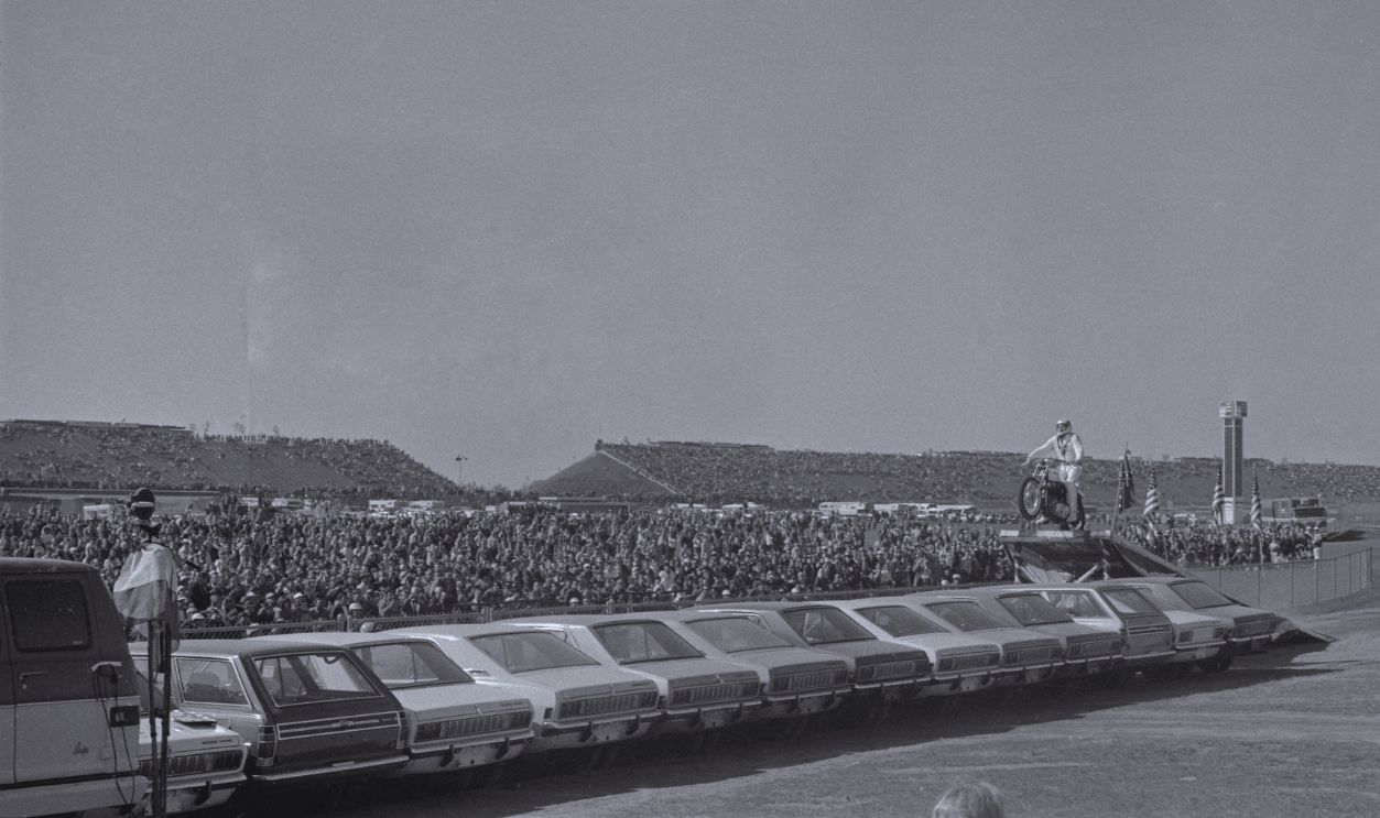 Gettyimages - 515106736, Evel Knievel Jumping Row of Cars (Original Caption) Motorcycle stunt man Evel Knievel sails over a line of 19 automobiles in a record breaking effort before the start of the Miller 500 stock car race at Ontario Motor Speedway. Knievel landed safely on a ramp, (not shown) breaking only the record, not his bones, as he occasionally has done in the past. Only 11 of the 19 cars which he jumped are shown here.