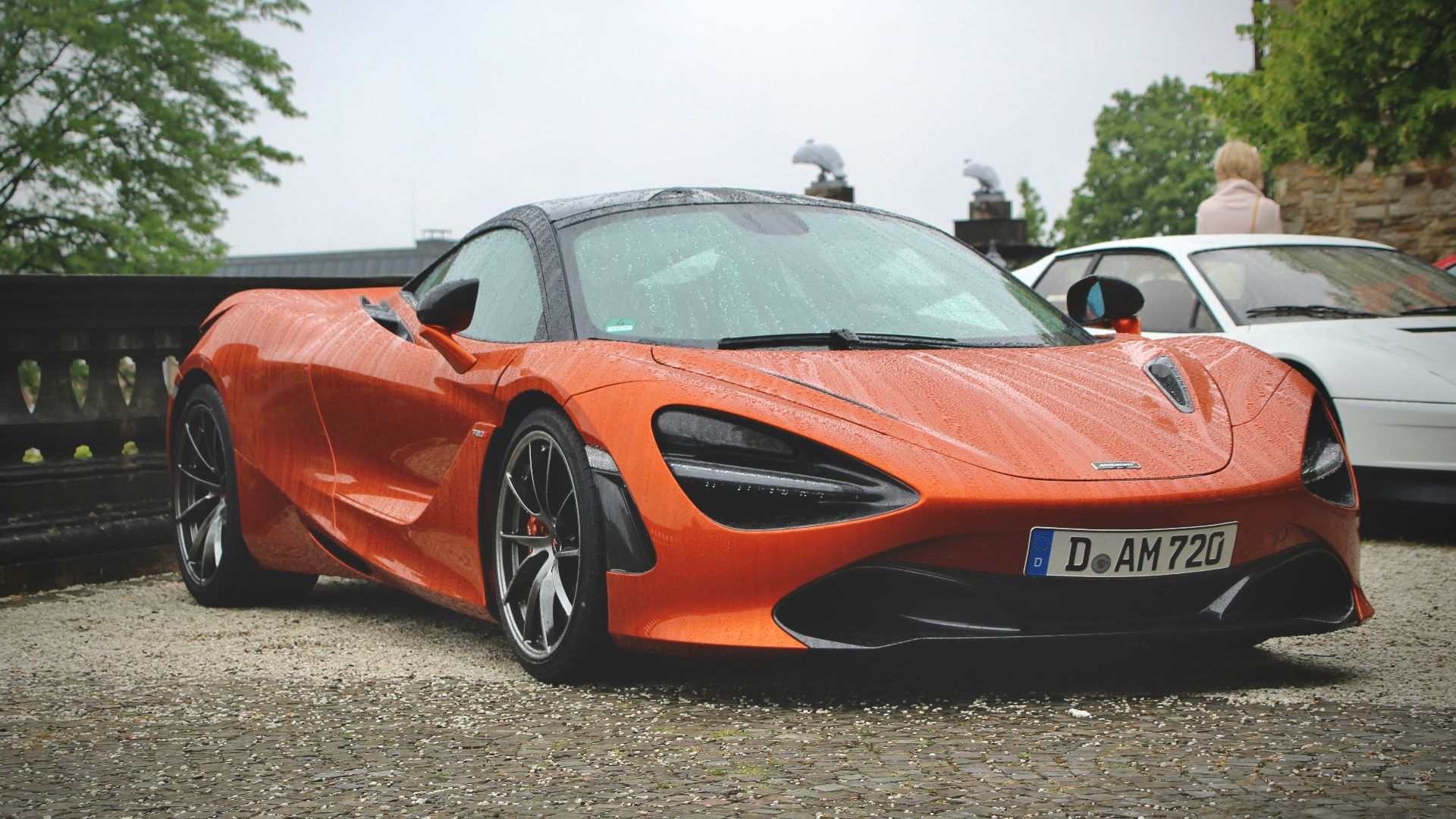 an orange sports car parked in a parking lot
